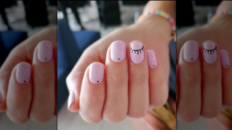 baby pink manicure with designs in black