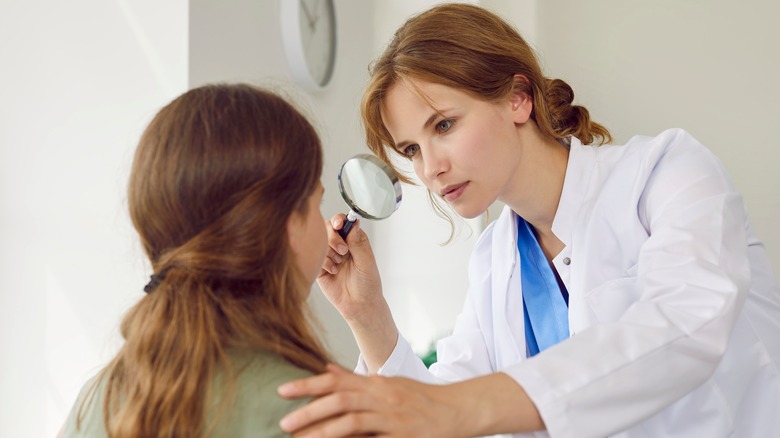 Dermatologist assessing patient's skin condition