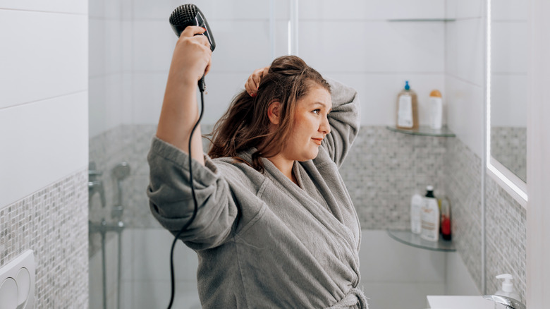 Woman blow drying hair 