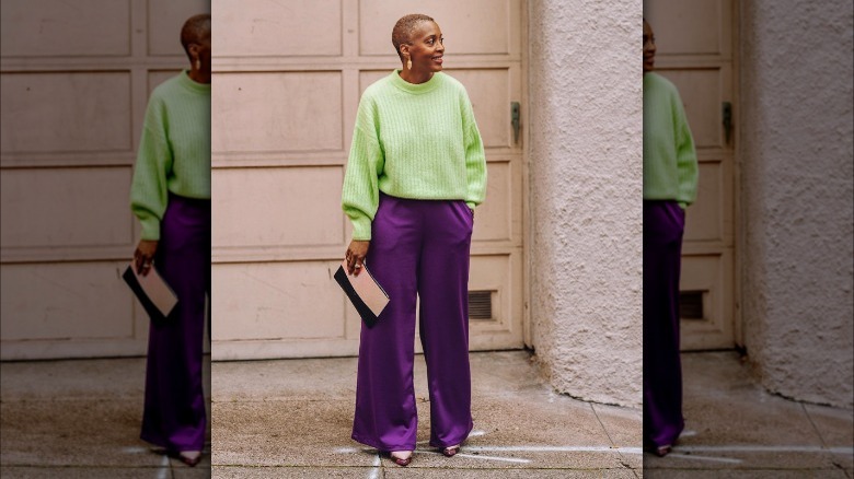 Woman in green sweater and purple pants