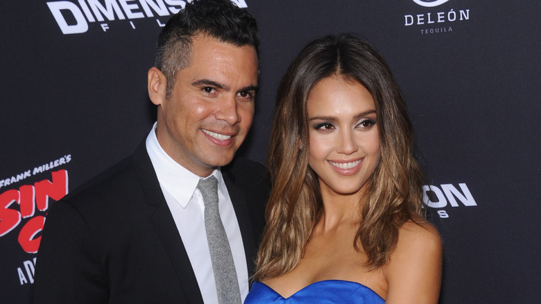 Jessica Alba in a blue dress and Cash Warren in a suit at an event