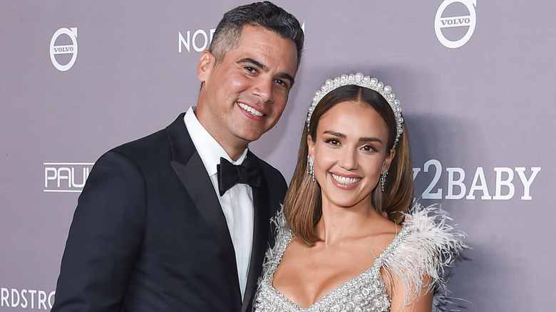 Jessica Alba in a silver headband and Cash Warren in a suit at an event