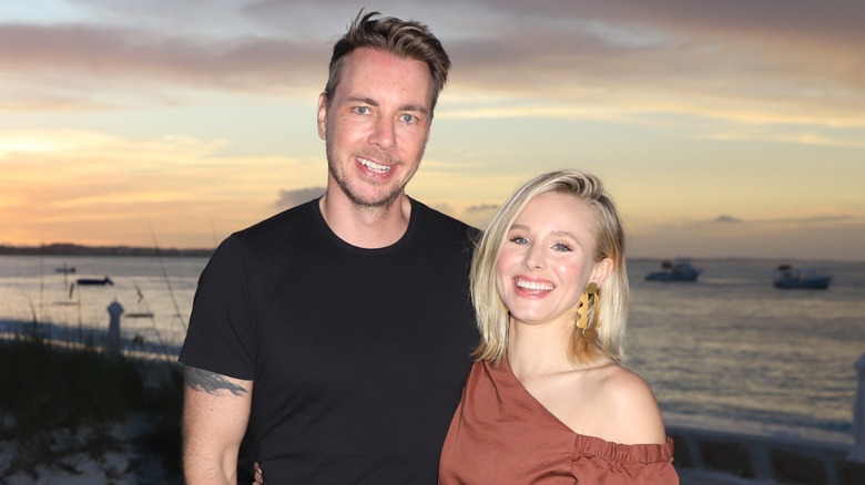 Kristen Bell and Dax Shepard posing in front of a sunset