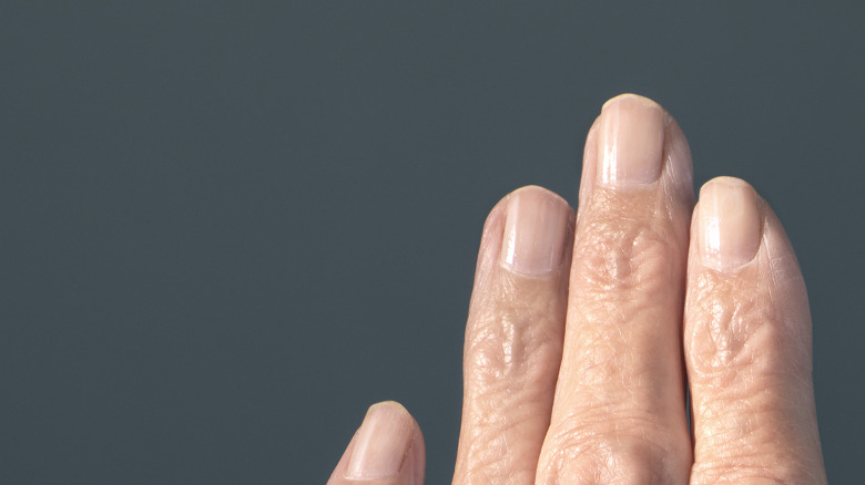 Older person's hand next to a younger person's hand