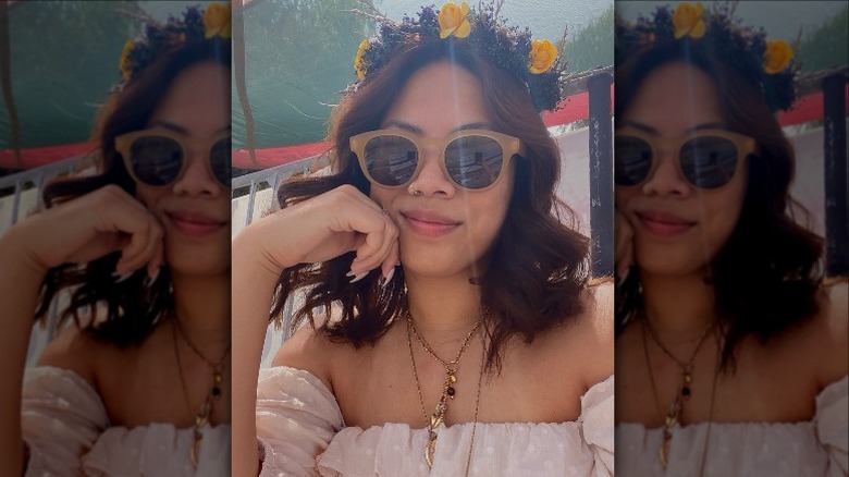 woman in sunglasses and a flower crown smirking