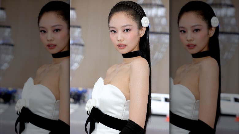 Jennie Kim poses at the Met Gala with a white rosette in her hair