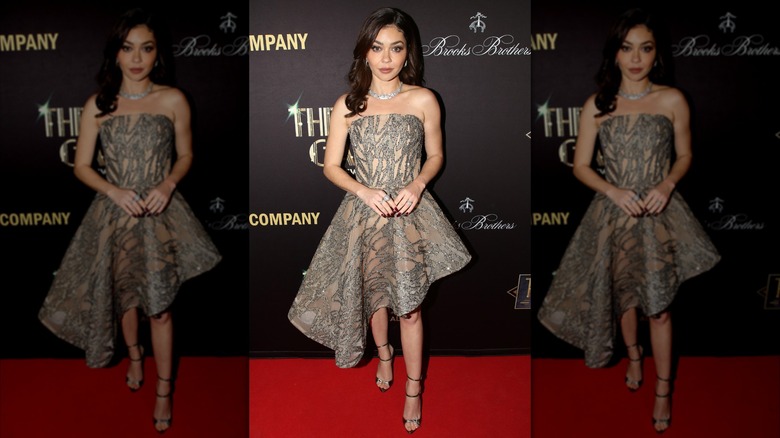 Sarah Hyland posing in an glitter dress with an asymmetrical hemline at a Broadway event