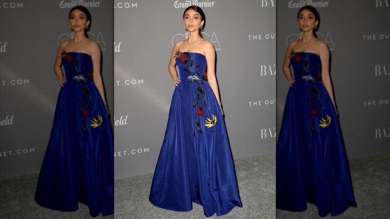 Sarah Hyland posing in a cobalt blue dress with flower embroidery at a 2018 event