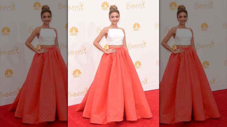 Sarah Hyland posing in a white cropped top and large, red skirt at the Emmys