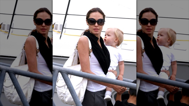 Angelina Jolie carrying Shiloh Jolie onto a boat