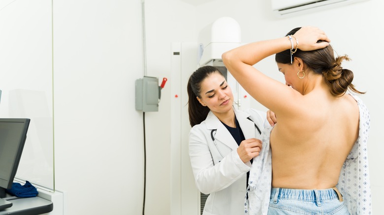 Doctor performs a breast exam on a patient