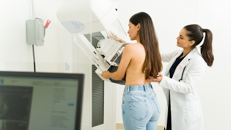 Patient undergoes a mammogram with doctor next to her