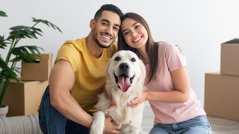 A couple smiling with their dogs