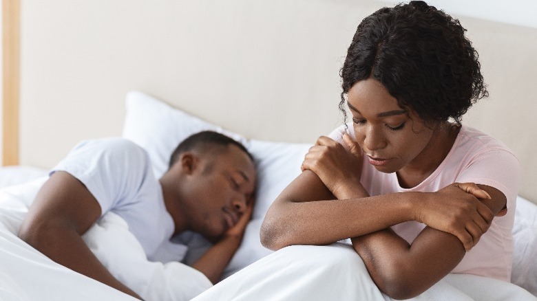 Woman unhappy in bed with man