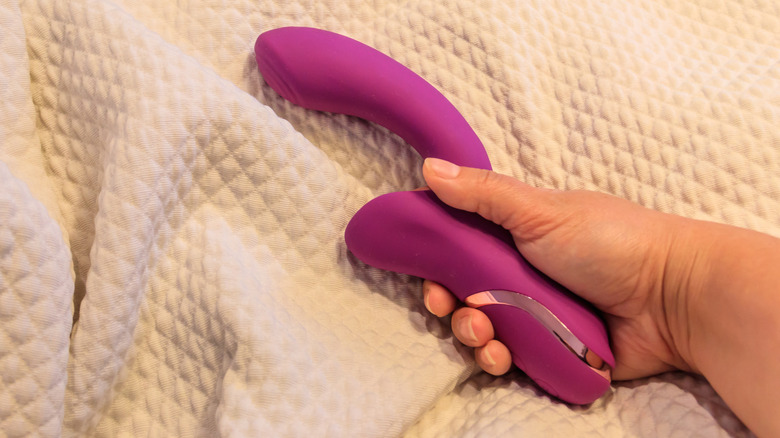 Hand holding pink sex toy