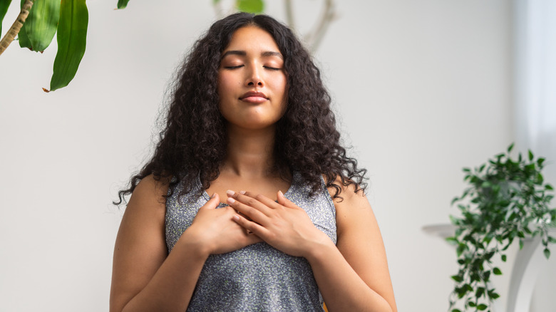 Woman with hands over chest meditating