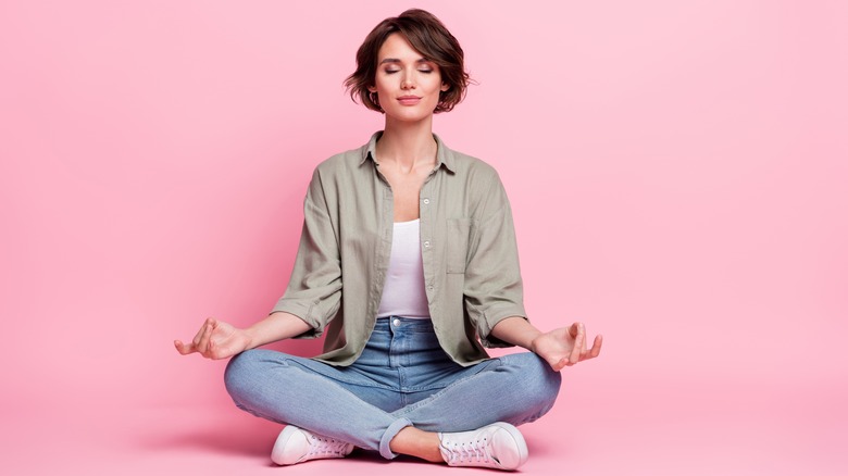 Woman meditation against pink background