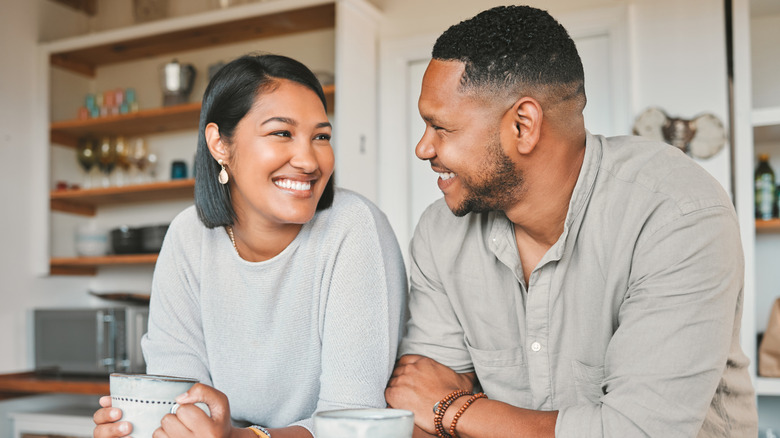 woman and man smiling and chatting over coffee