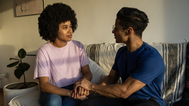 Two people holding hands and having a serious discussion