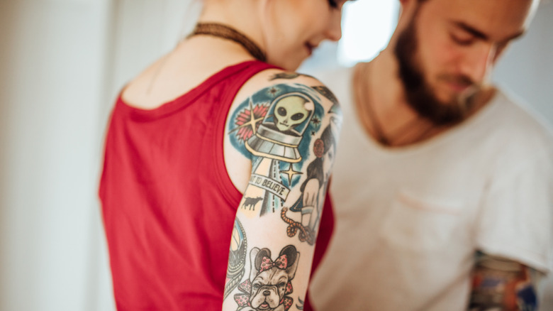 Person with alien tattoo on shoulder