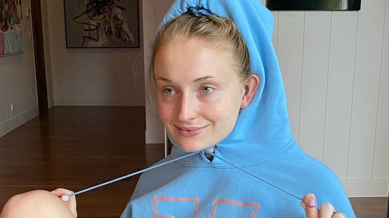 Sophie Turner wearing a hood and no makeup