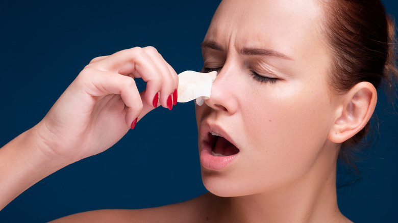 A woman removing a pore strip off their nose