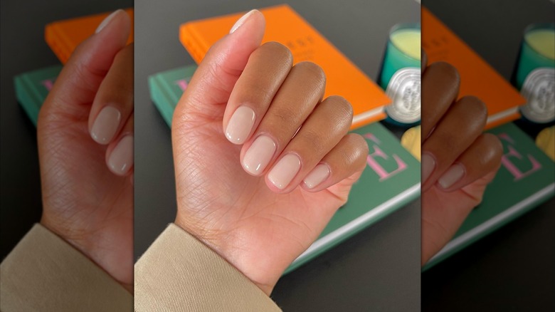 Folded hand showing white-toned, soap-style nails