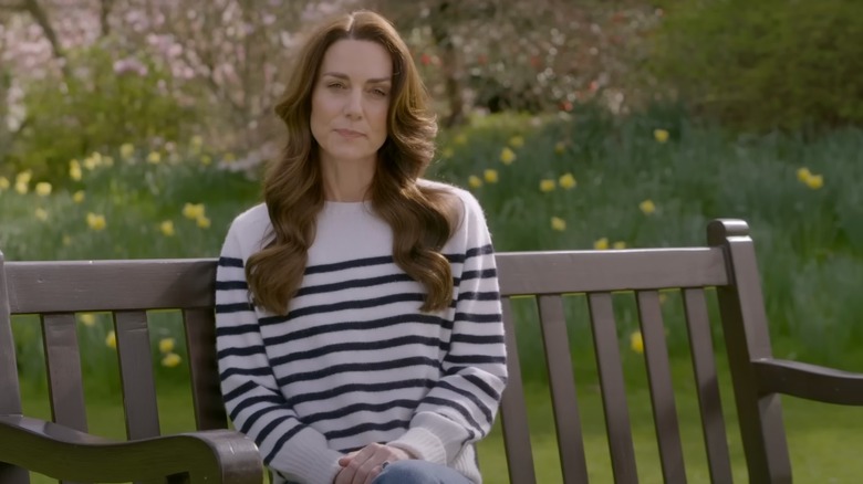 Kate Middleton in a blue and white sweater sitting outside