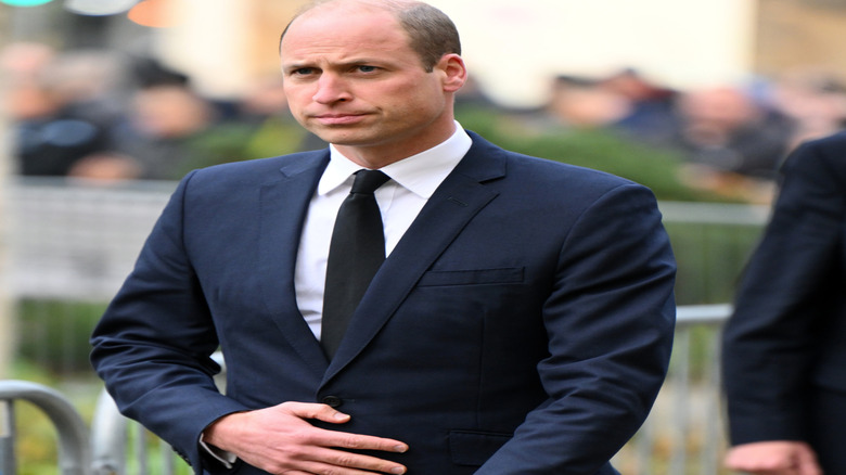 Prince William looking stern wearing a suit at an event