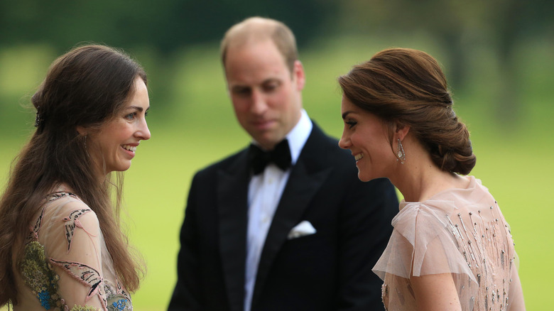 Rose Hanbury in a gown, Kate Middleton in a peach gown, and Prince William in a tuxedo at an event