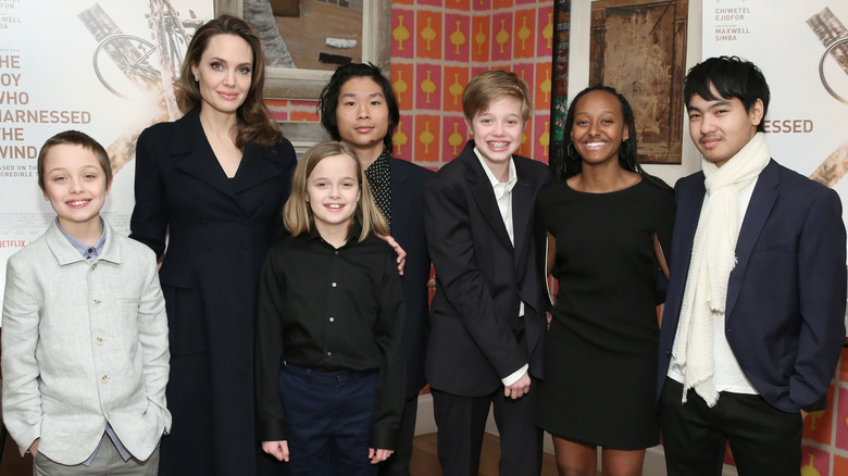 Shiloh Jolie sporting a suit smiling alongside siblings and mom Angelina Jolie