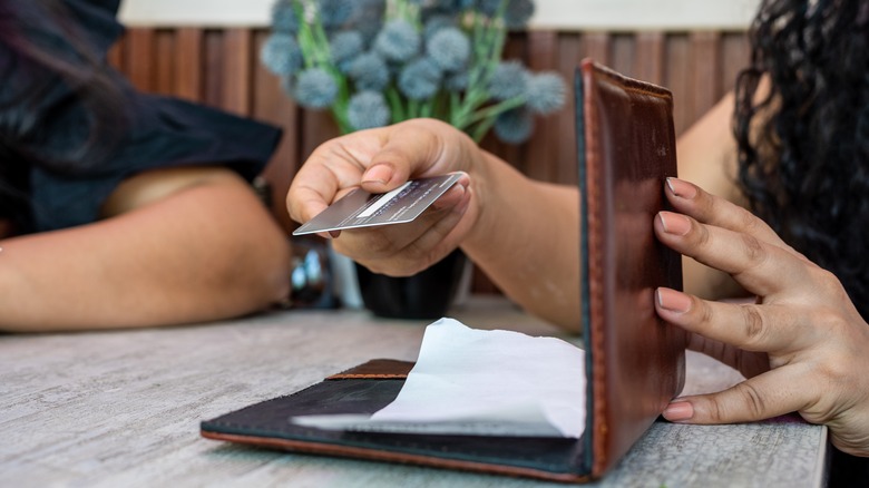 woman paying bill with card