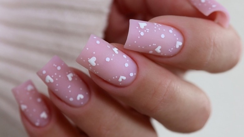 Matte pink nails with white hearts and dots