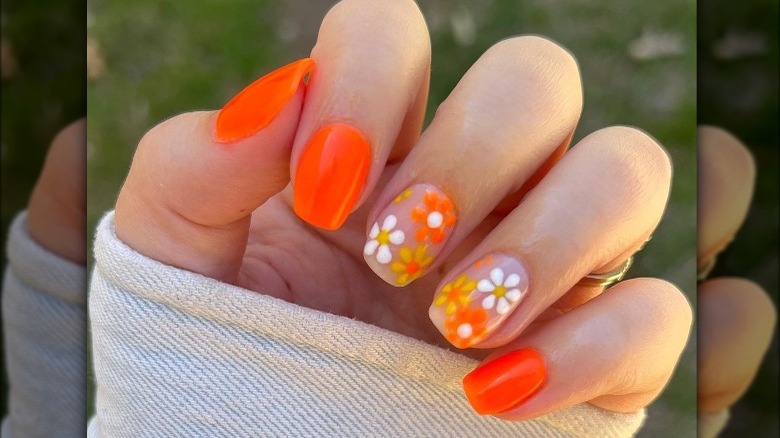 Hand with orange floral manicure
