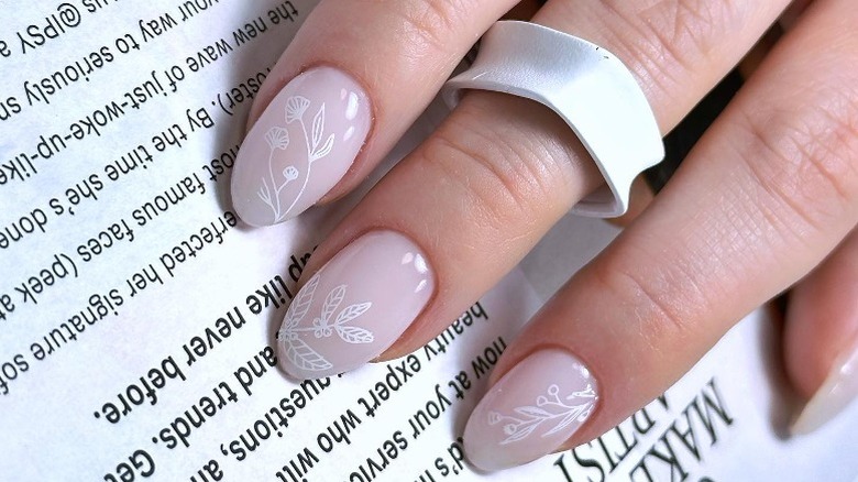 Hand with pale pink floral fingernails 