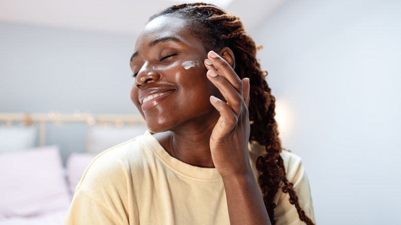 Woman applying moisturizer