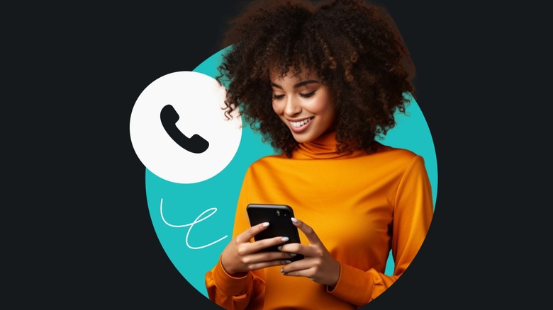 woman with orange turtleneck smiles while staring at phone