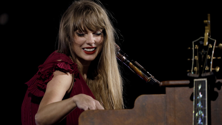 Taylor Swift smiling while playing piano