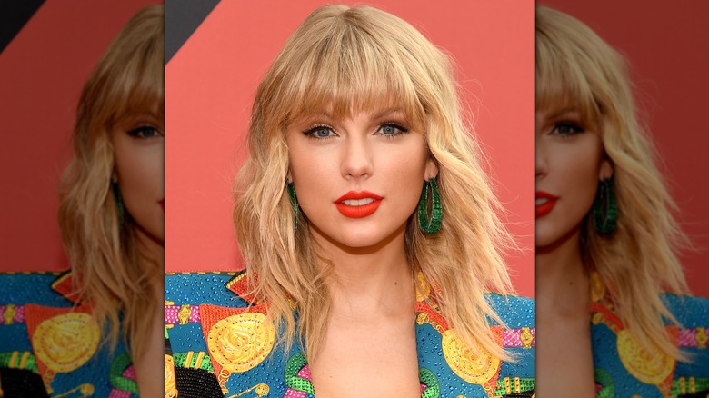 Taylor Swift looking into the camera with a shaggy, shoulder-length hairstyle