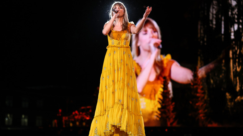 Taylor Swift onstage in a long yellow gown