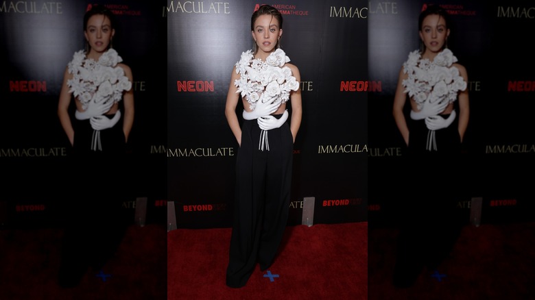 Sydney Sweeney on the red carpet in black pants and sculptural top