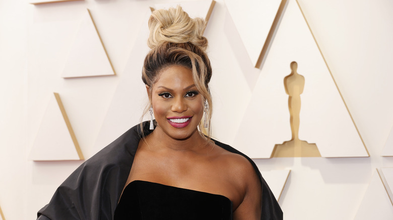 Laverne Cox poses and smiles with her hair in an updo