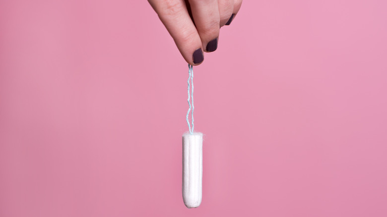 woman holding a tampon