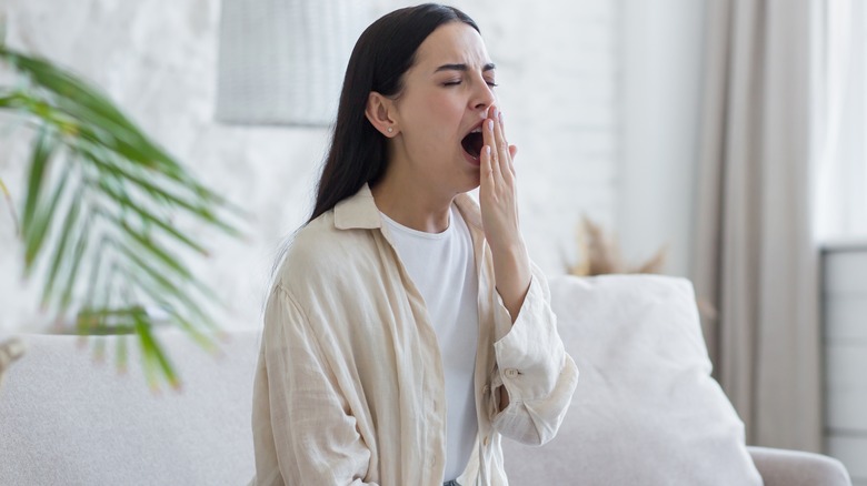 Woman yawning covering mouth