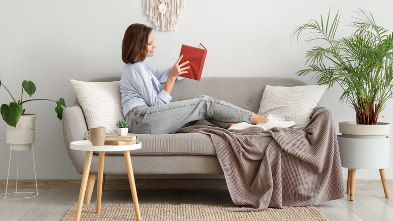 Woman reading book on a couch