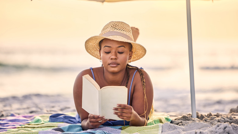 Black woman reading on the beach