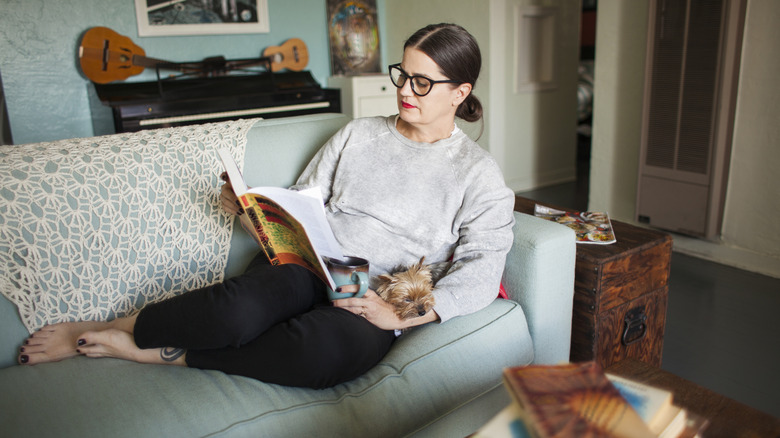 A woman reading a book on the couch