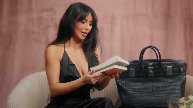 Kim Kardashian holding books