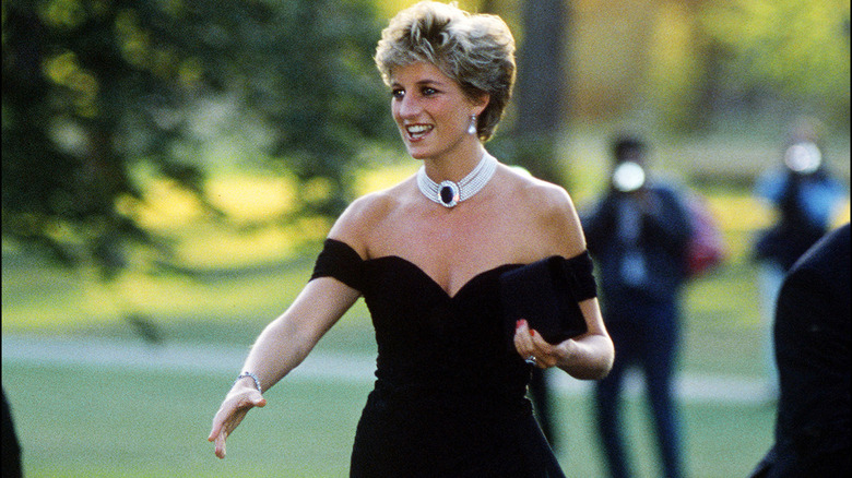 Princess Diana wearing a little black dress and shaking someone's hand