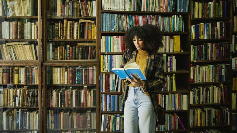 Woman reading book in library